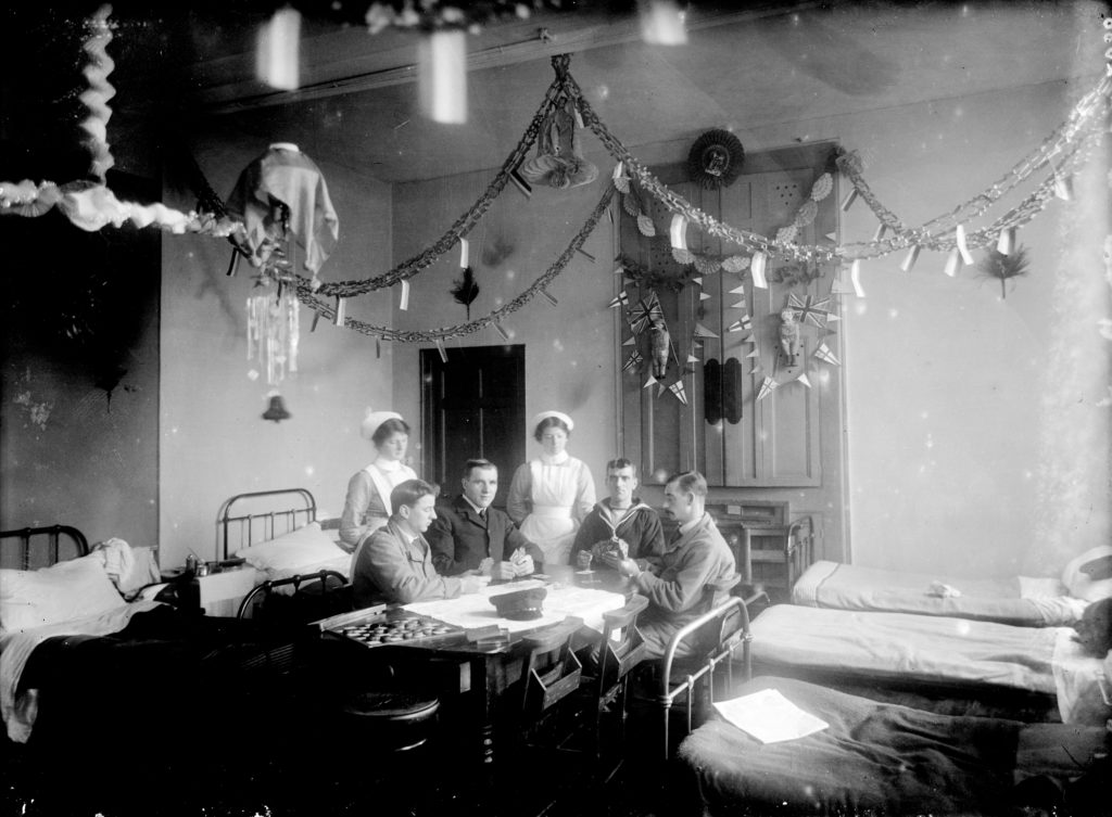 Nurses and patients (one sailor) playing cards in the ward at the Royal Cornwall Infirmary, Christmas 1915. Photographer: A W Jordan. © From the collection of the RIC.